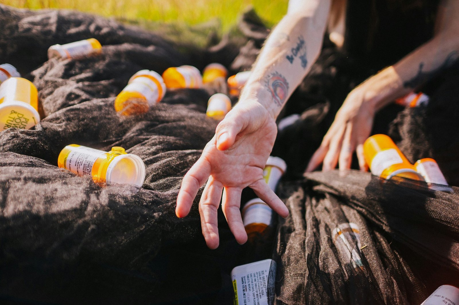 a person holding out their hand to a bunch of bottles